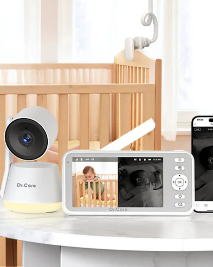 Dr. Care baby camera and monitor shown beside a crib with phone app preview