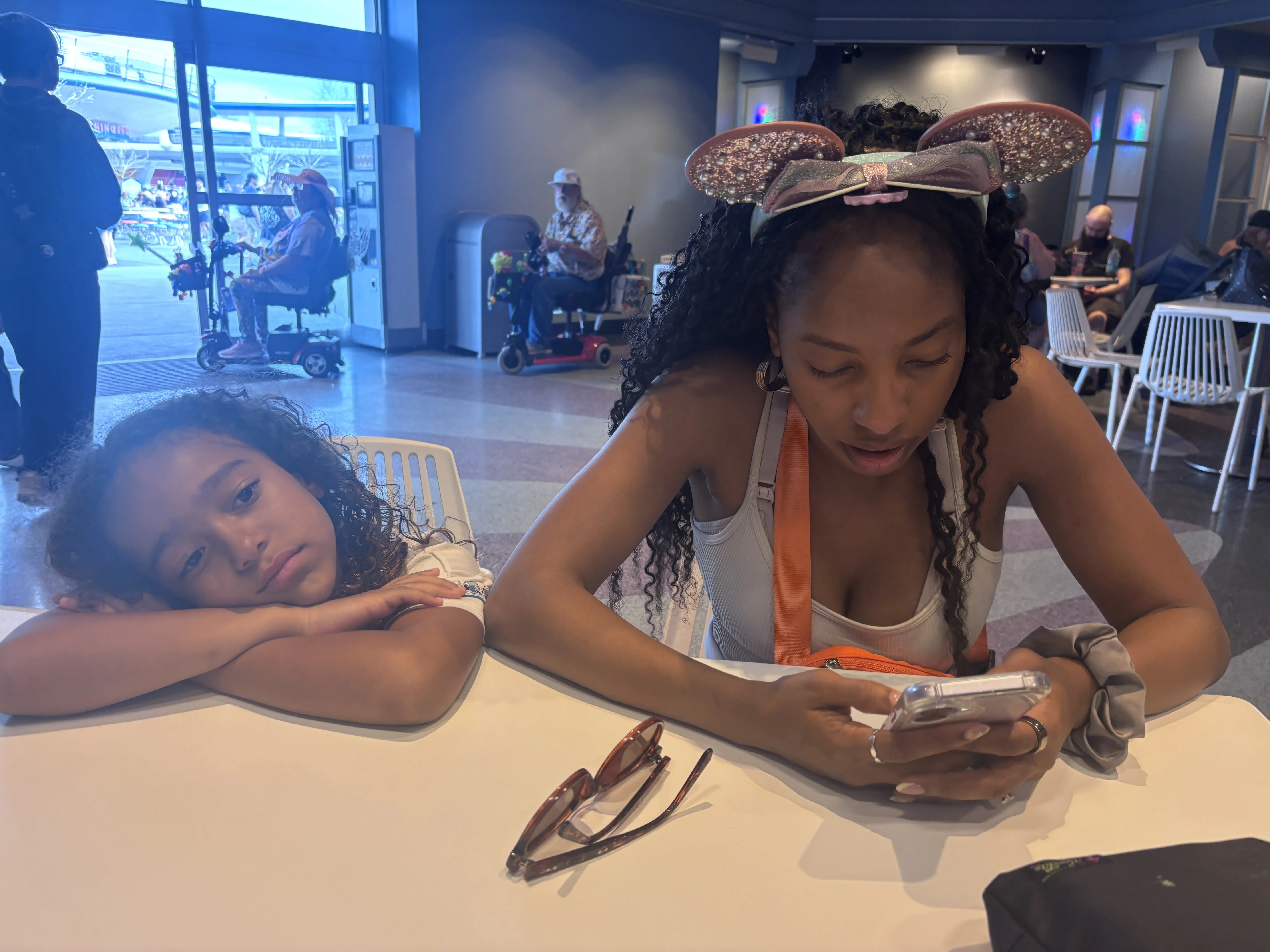 Jess and Niabelle sitting tired at the airport after the Disney World trip