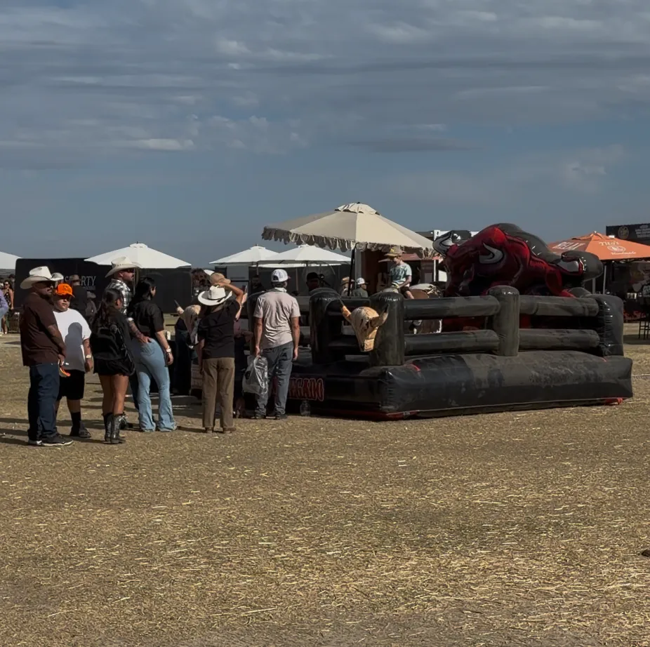 Kids riding mechanical bulls in the Kids Corral area at Desert Rodeo