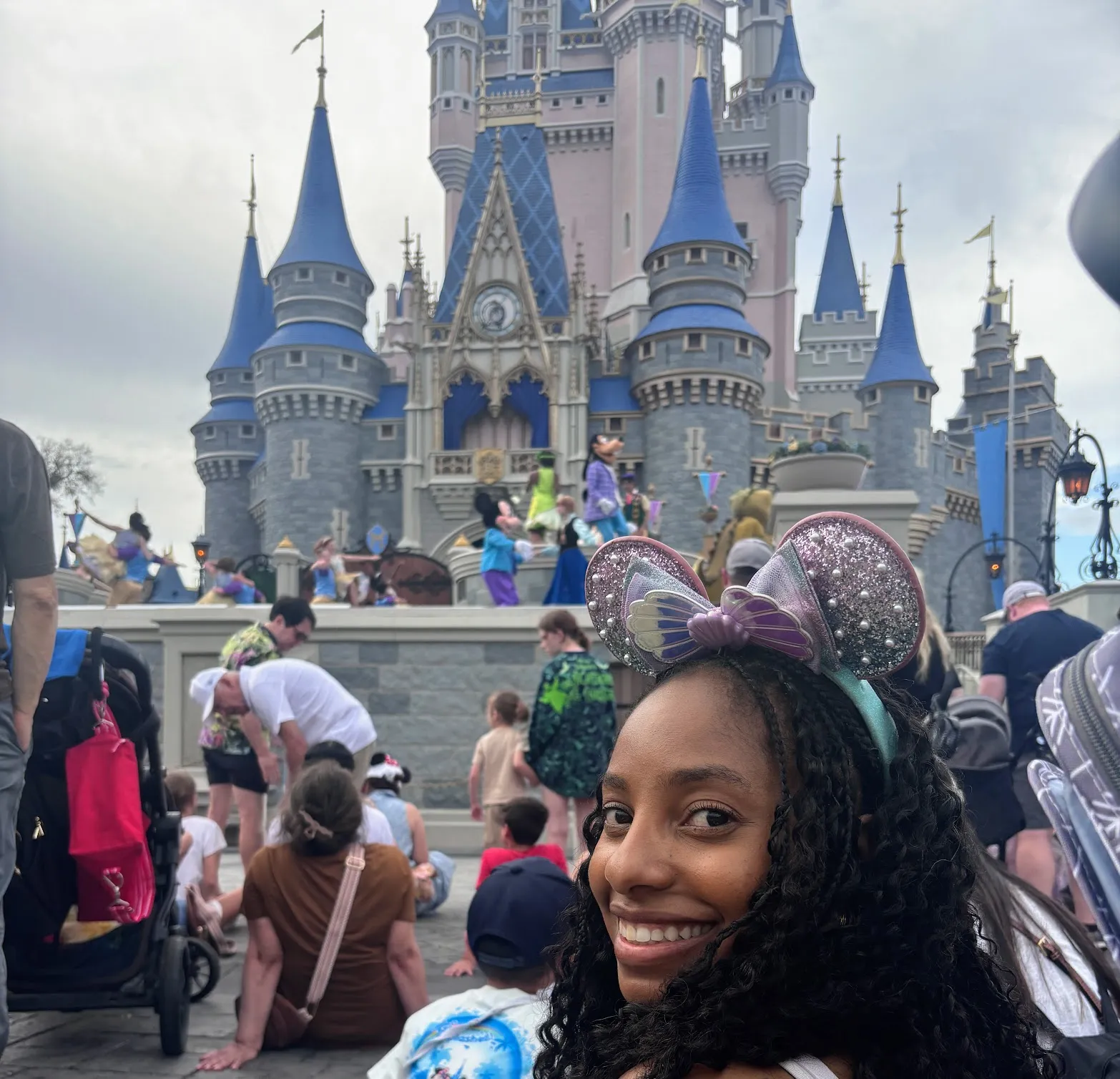 Jess smiling in sparkly Minnie ears in front of Cinderella Castle at Magic Kingdom