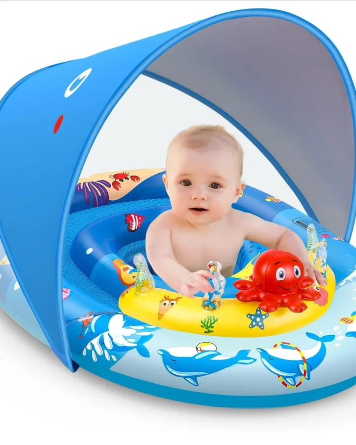 Baby sitting in a blue pool float with canopy and attached toys